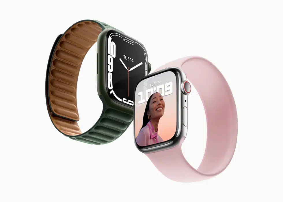 Två Apple Watch Series 7 visas med olika armband, ett i grönt och ett i rosa, båda med stora, kurvade Retina-skärmar.