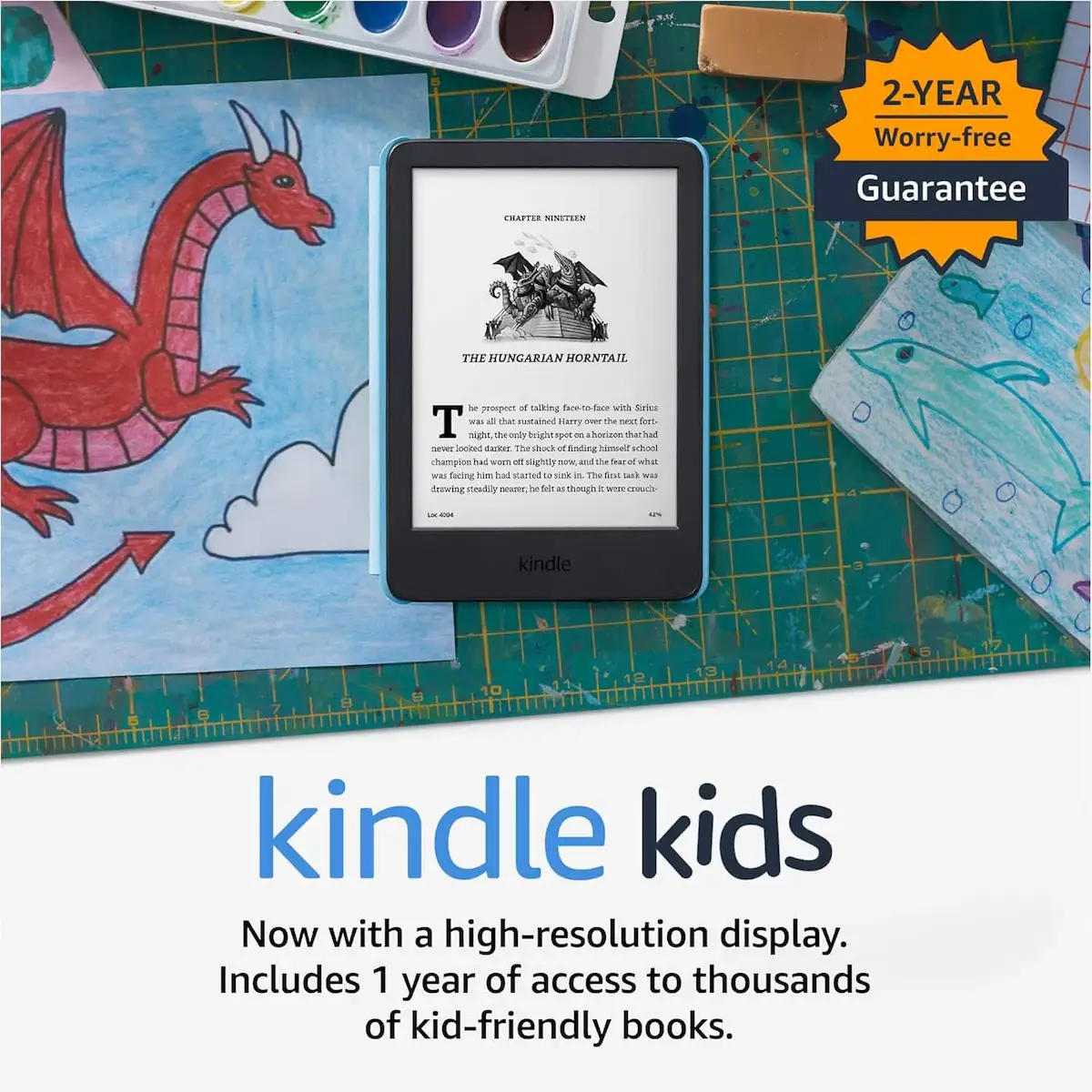 Kindle Kids läsplatta med tillgång till barnvänliga böcker, liggande på ett skrivbord med teckningar.