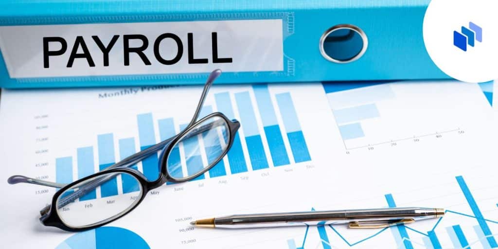 Blue and white items on desk including glasses, payroll binder and charts and graphs